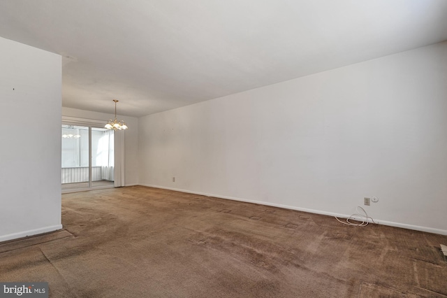 carpeted empty room with a chandelier