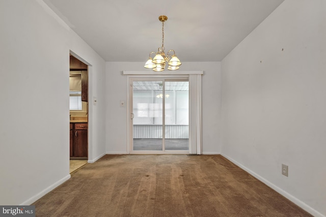 unfurnished dining area featuring an inviting chandelier and carpet floors