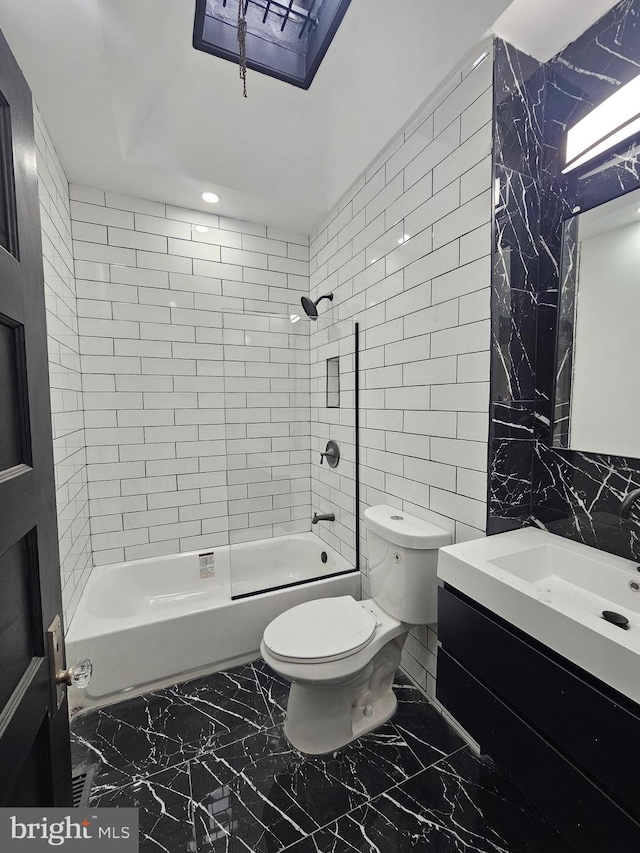 full bathroom with tiled shower / bath combo, toilet, tile walls, and vanity