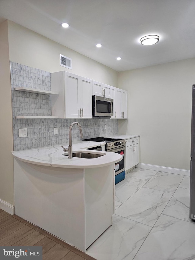 kitchen featuring backsplash, sink, white cabinets, and appliances with stainless steel finishes