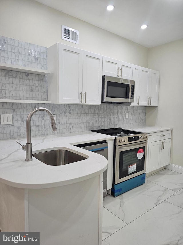 kitchen featuring sink, light stone counters, white cabinetry, and stainless steel appliances