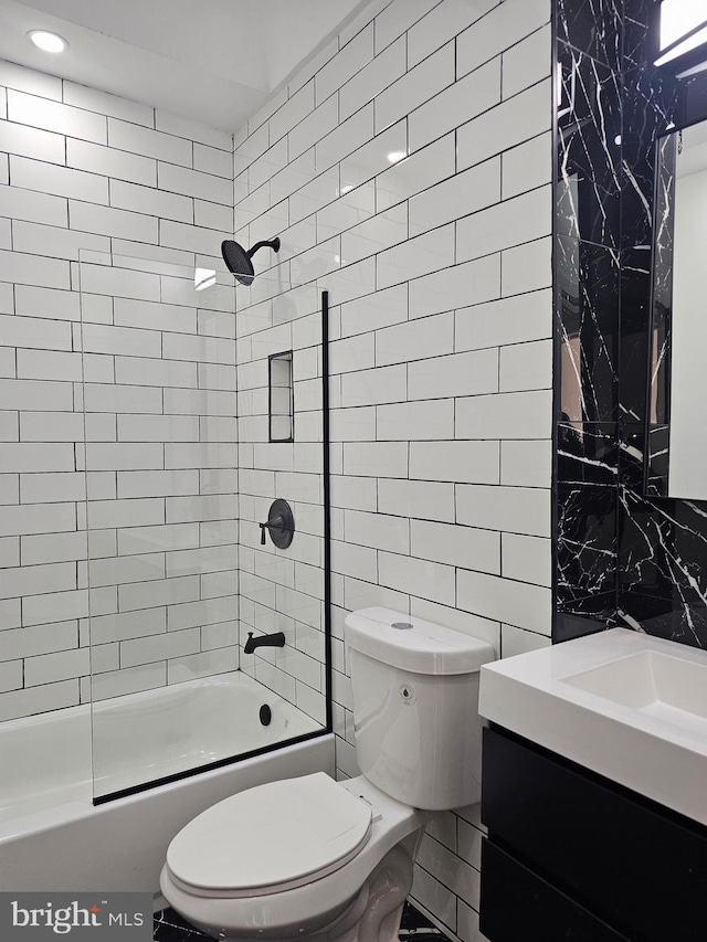 full bathroom featuring tiled shower / bath combo, toilet, decorative backsplash, and tile walls