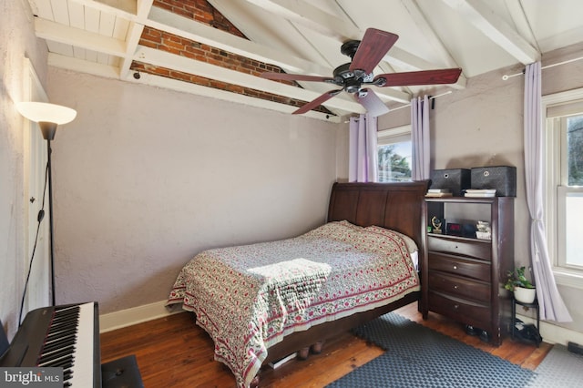 bedroom featuring a ceiling fan, vaulted ceiling with beams, wood finished floors, and baseboards