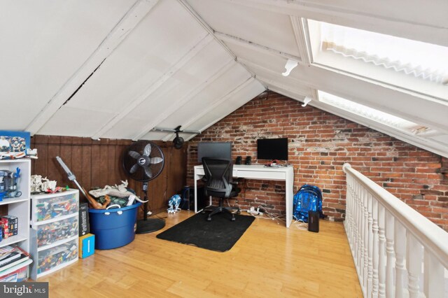 office with hardwood / wood-style flooring, brick wall, and lofted ceiling with beams