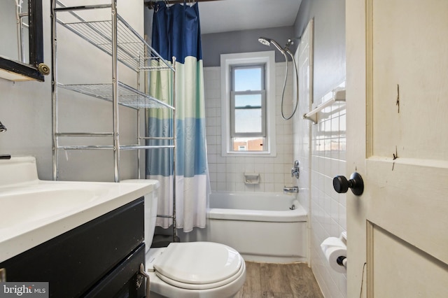 bathroom with toilet, shower / bath combo with shower curtain, wood finished floors, and vanity