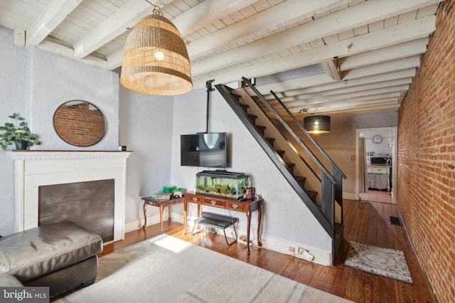 living room with beamed ceiling, wood ceiling, wood-type flooring, and brick wall