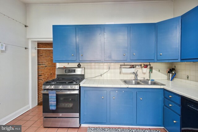 kitchen featuring dishwasher, sink, stainless steel gas range oven, blue cabinetry, and light tile patterned floors