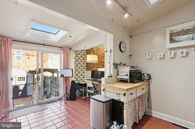 office area featuring tile patterned floors, visible vents, track lighting, and vaulted ceiling with skylight