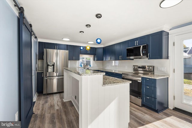 kitchen featuring stainless steel appliances, blue cabinets, wood-type flooring, a barn door, and decorative light fixtures