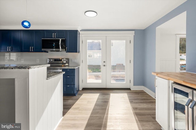 kitchen with french doors, stainless steel appliances, blue cabinetry, light hardwood / wood-style floors, and wine cooler