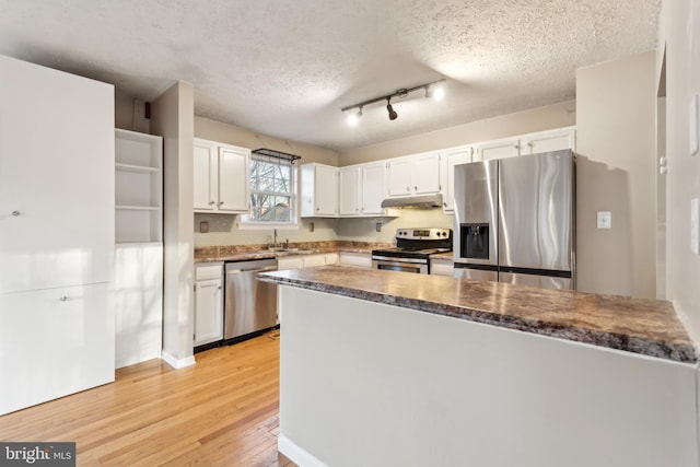 kitchen with a textured ceiling, sink, white cabinetry, and stainless steel appliances