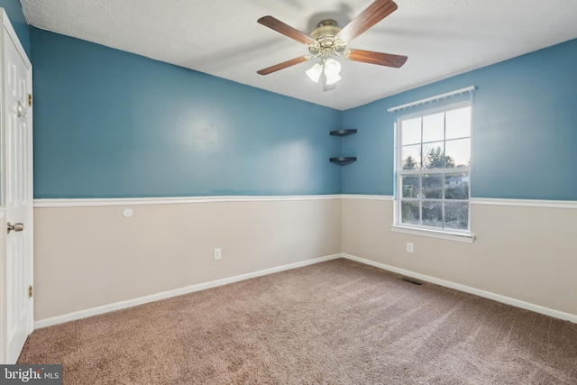 carpeted spare room featuring a textured ceiling and ceiling fan