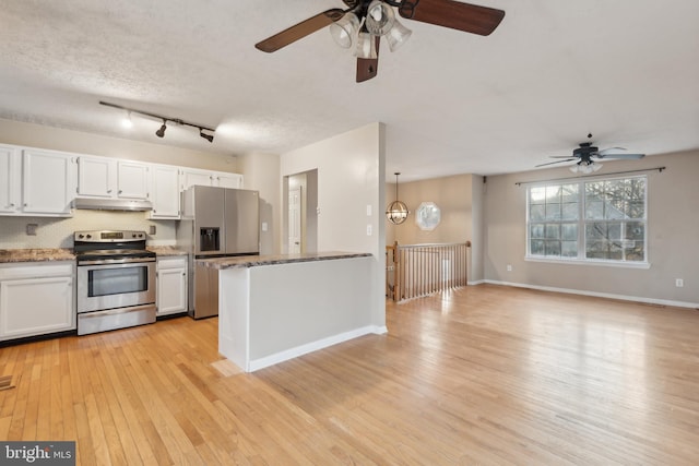 kitchen featuring a textured ceiling, stainless steel appliances, white cabinetry, and hanging light fixtures