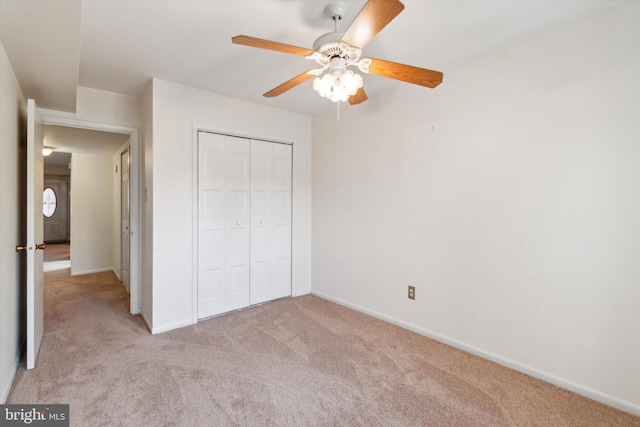 unfurnished bedroom featuring light carpet, a closet, and ceiling fan