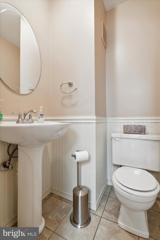 bathroom featuring toilet, sink, and tile patterned flooring