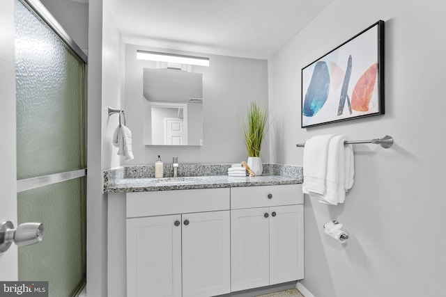 bathroom featuring vanity and a shower with shower door