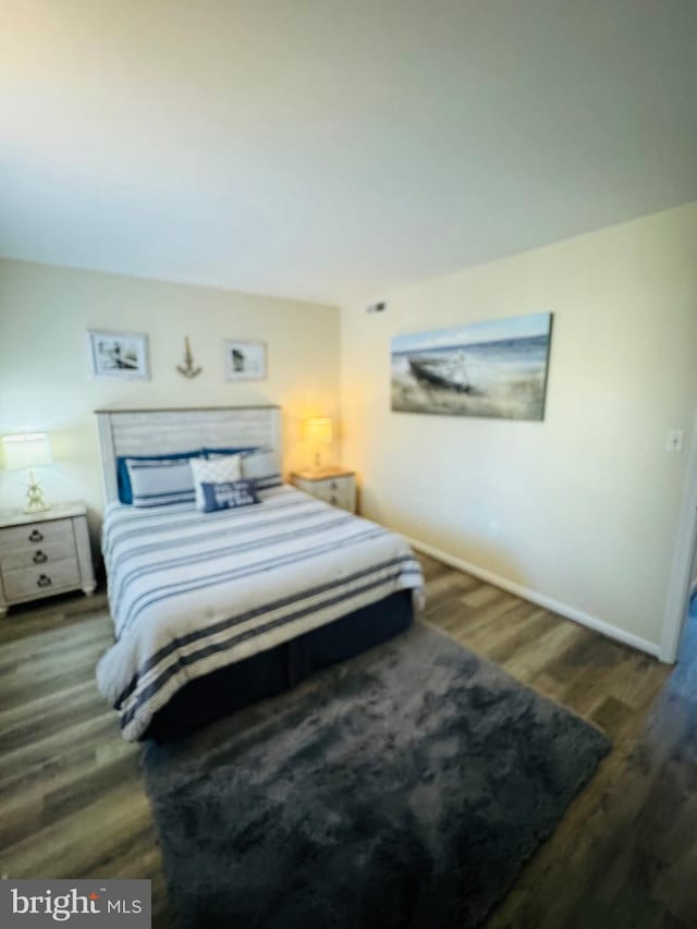 bedroom with dark hardwood / wood-style flooring