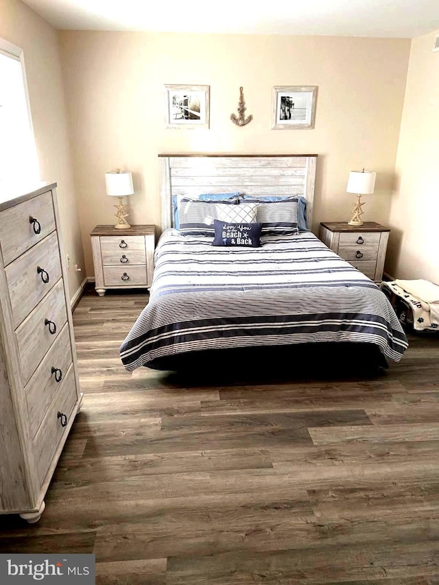 bedroom featuring baseboards and wood finished floors