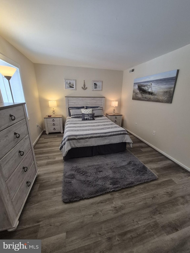 bedroom with dark hardwood / wood-style flooring