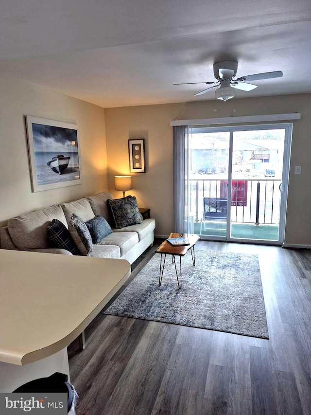 living room featuring ceiling fan, wood finished floors, and a wealth of natural light
