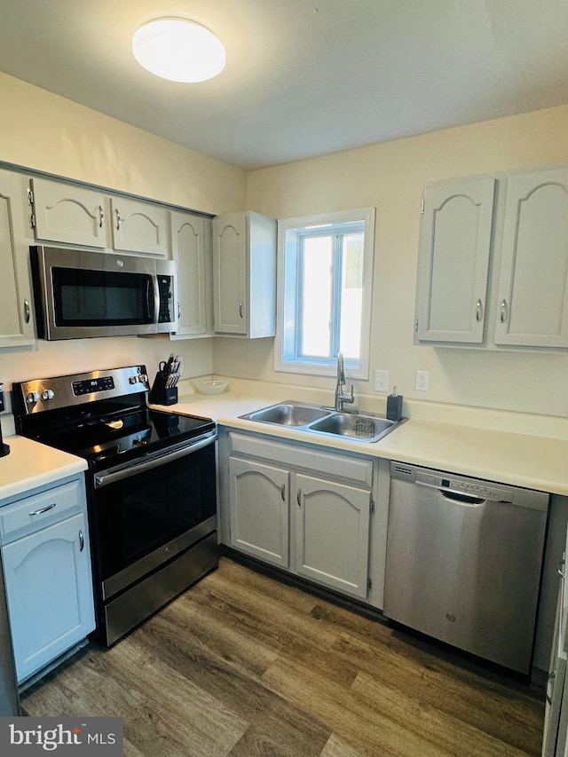 kitchen featuring white cabinets, stainless steel appliances, dark hardwood / wood-style floors, and sink