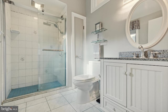 bathroom featuring toilet, vanity, tile patterned floors, and a shower with shower door