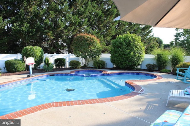 view of swimming pool with a patio area and an in ground hot tub