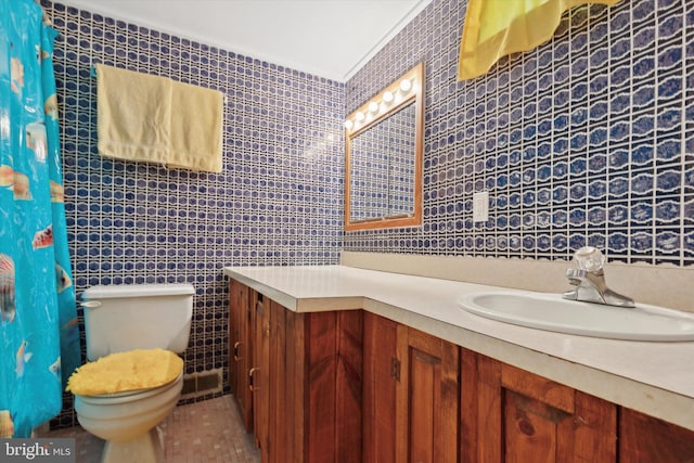 bathroom with tile walls, tile patterned flooring, vanity, and toilet