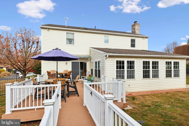 rear view of property with a yard and a deck