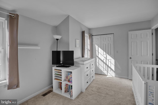 bedroom with baseboards, visible vents, a closet, and light carpet