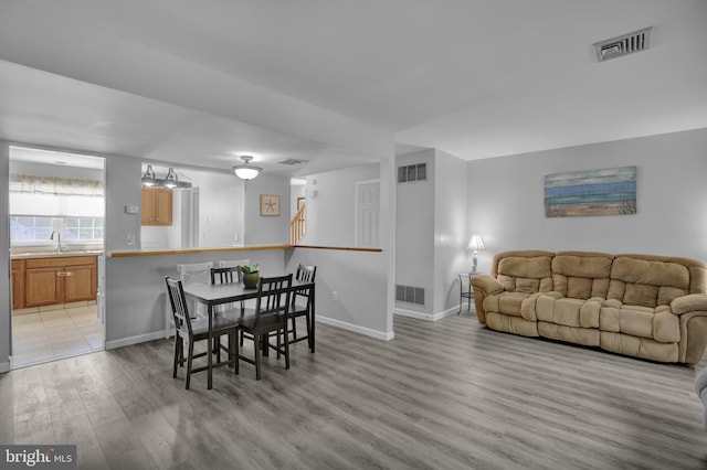 dining area featuring visible vents, light wood-style flooring, and baseboards