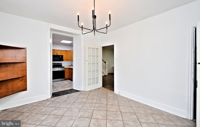 unfurnished dining area with an inviting chandelier and light tile patterned floors