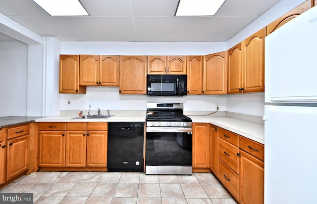 kitchen with light tile patterned flooring, a paneled ceiling, sink, and black appliances