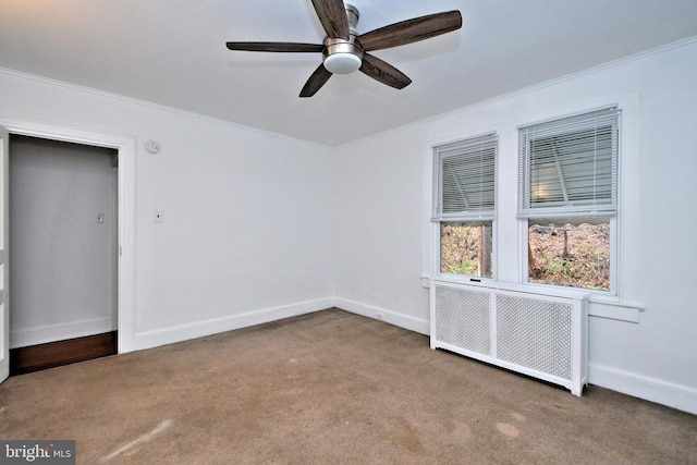 carpeted empty room featuring radiator, ornamental molding, and ceiling fan