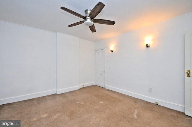 carpeted empty room featuring ornamental molding and ceiling fan