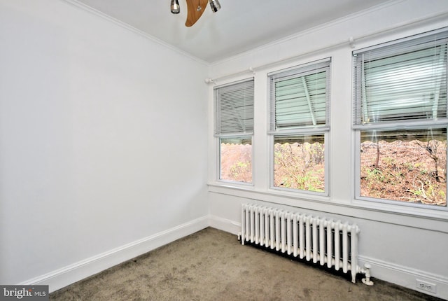 carpeted spare room with crown molding, radiator heating unit, and ceiling fan