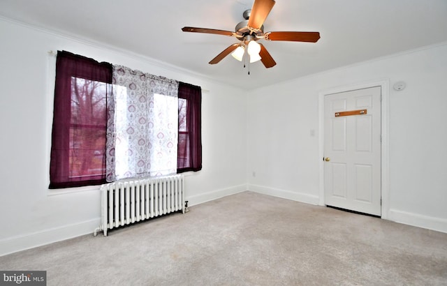 unfurnished room featuring crown molding, light carpet, radiator heating unit, and ceiling fan