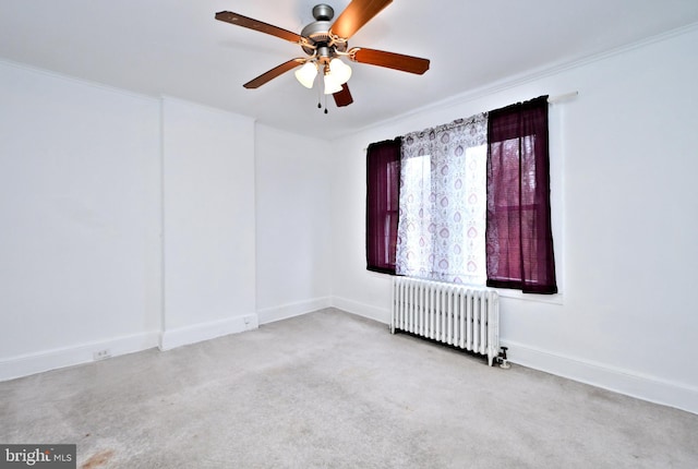 carpeted empty room featuring radiator heating unit and ceiling fan