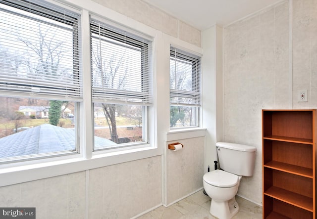 bathroom featuring tile walls and toilet