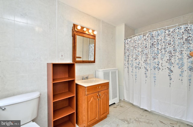 bathroom featuring a shower with curtain, vanity, tile walls, and toilet