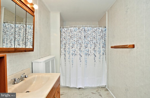 bathroom featuring vanity, tile walls, and walk in shower