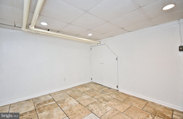 tiled spare room with a drop ceiling