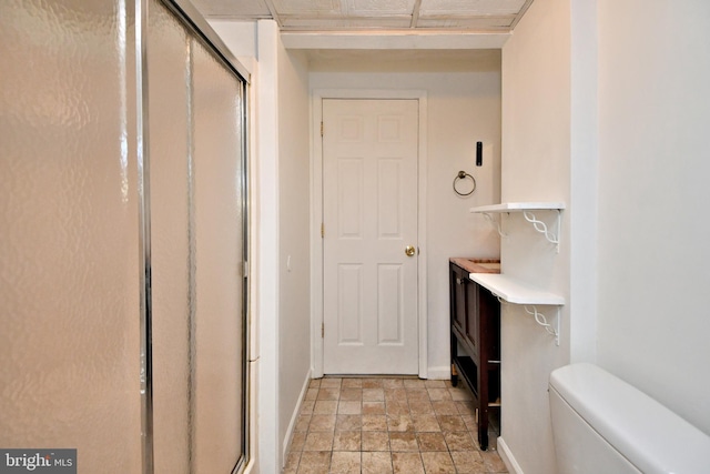 interior space featuring a shower with door and toilet