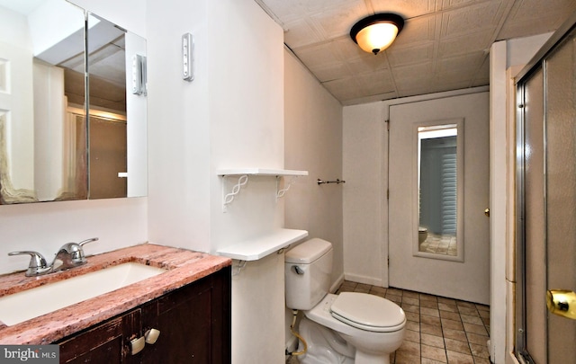 bathroom featuring vanity, toilet, tile patterned floors, and a shower with shower door