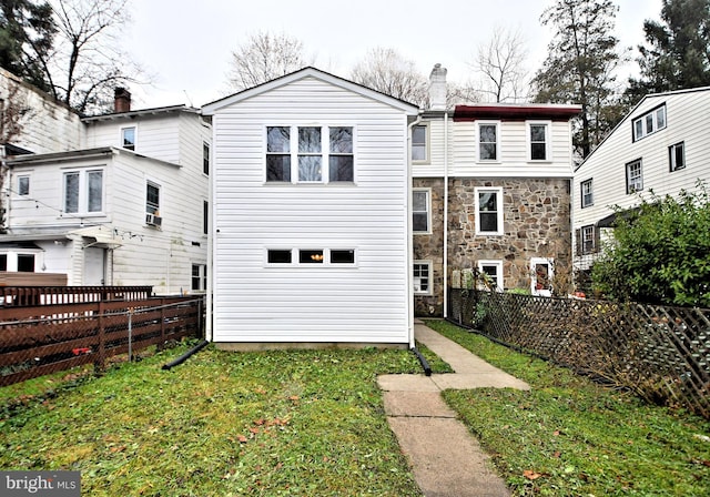 rear view of property featuring a lawn