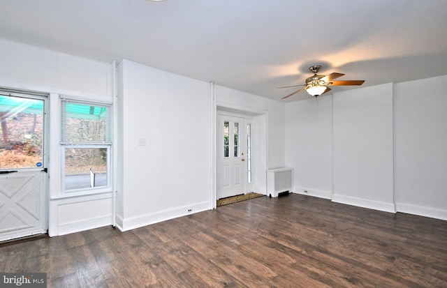 interior space with radiator heating unit, dark hardwood / wood-style floors, a wealth of natural light, and ceiling fan