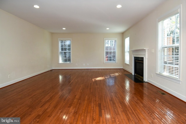 unfurnished living room with dark hardwood / wood-style floors and plenty of natural light