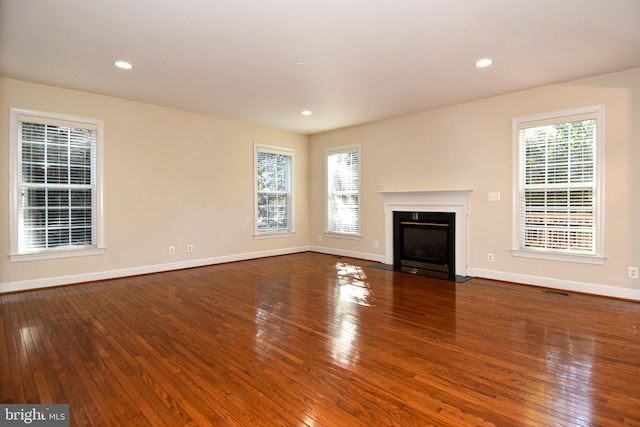 unfurnished living room with a wealth of natural light and hardwood / wood-style floors