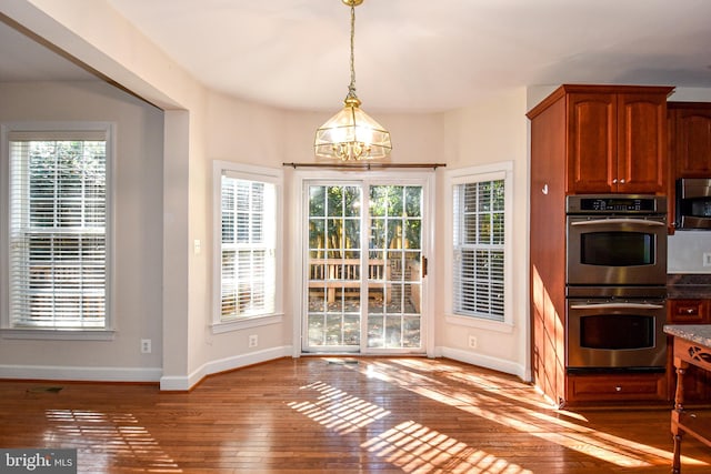 kitchen featuring light hardwood / wood-style flooring, a notable chandelier, appliances with stainless steel finishes, and a wealth of natural light