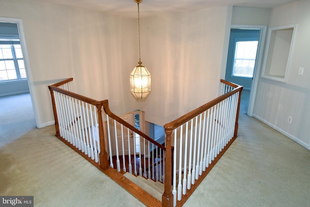 stairs with a notable chandelier and carpet